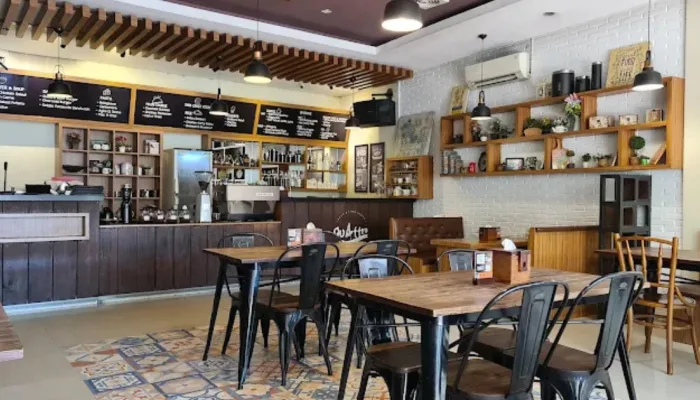 Desain interior elegan dan mewah Quattro Cafe Purwokerto dengan jendela kaca besar dan dekorasi tanaman