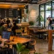 Suasana cafe instagramable di Purwokerto dengan pengunjung sedang WFC laptopan dan berfoto di area estetik